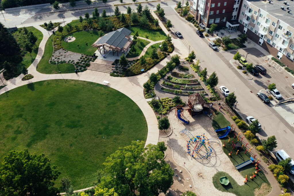 Cottageville Park’s great lawn, picnic shelter, playground, and community garden, situated next to the Project for Pride in Living Oxford Village affordable housing complex.